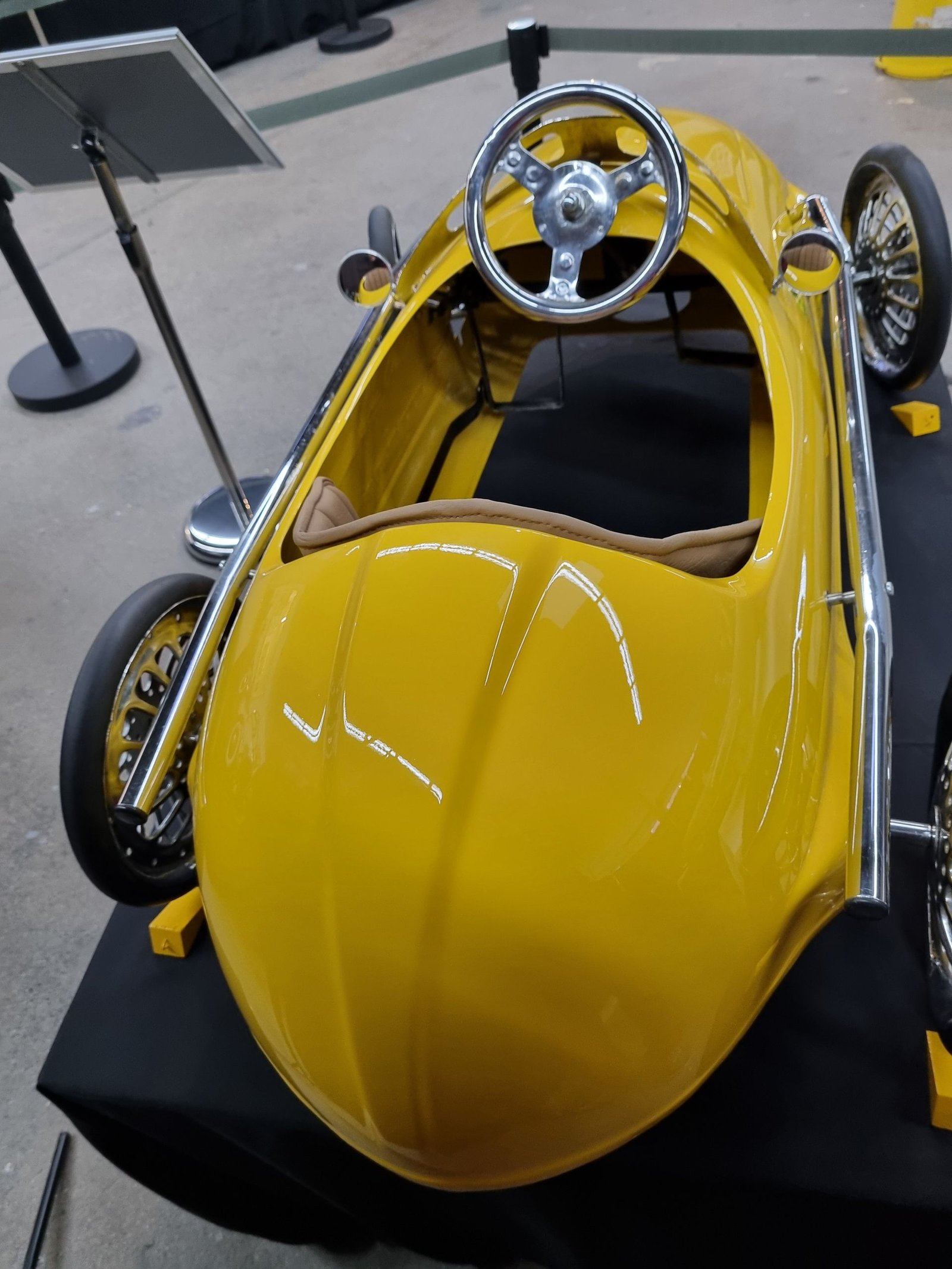 Ein gelbes Auto mit Lenkrad ist ausgestellt